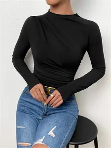 Detalle del elegante fruncido en el hombro de una camiseta negra ajustada de manga larga