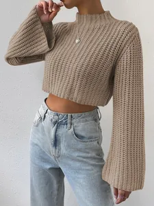 Detail shot of women's beige cropped knit sweater featuring flared sleeves and mockup neck.