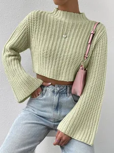 Close-up of light green knit cropped sweater with mock neck and flared sleeves