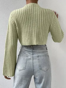 Back view of a cropped light green knit sweater with flare sleeves and mock neck