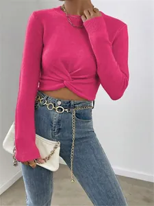 Detailaufnahme des eng anliegenden fuchsiafarbenen Pullovers mit Knotendetail vorne.