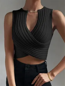 Nahaufnahme eines schwarzen gerippten Strick-Crop-Tops mit goldener Kettenverzierung am Hals