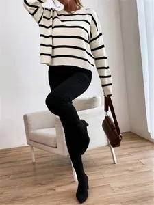 Striped knit pullover sweater styling detail with black pants and boots