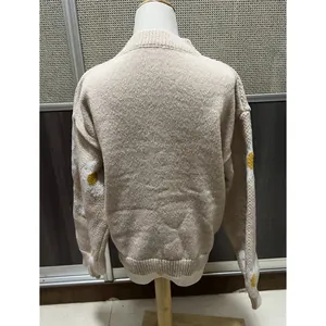 Vue arrière détaillée d'un pull en maille beige oversize avec des motifs de marguerites