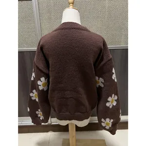 Vue arrière du pull en maille marron avec des motifs de marguerites blanches aux manches