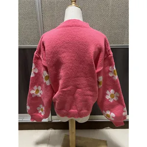 Vue arrière détaillée d'un pull en maille rose avec motifs marguerites sur les manches