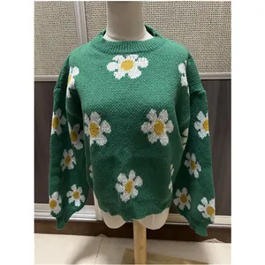 Vue de face d'un pull en tricot vert avec des motifs de marguerites blanches sur un mannequin