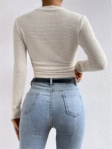 Achteraanzicht van een crème wafelgebreide crop top met lange mouwen en rimpels
