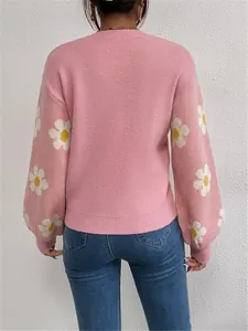 Vue arrière d'un pull en maille rose avec des motifs de marguerites blanches sur les manches