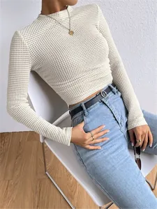 Gedetailleerd overzicht van het elegante witte damesshirt met lange mouwen en wafelstructuur