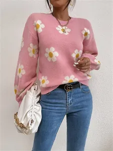 Vue détaillée d'un pull en tricot rose avec des motifs de fleurs de marguerites blanches