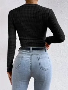 Achteraanzicht van een slanke zwarte dames crop top met lange mouwen en wafelstructuur