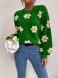 Gros plan détaillé d'un pull vert à col rond avec des motifs de fleurs blanches éclatantes