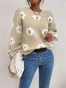 Détail du pull en maille beige avec motif marguerite blanche et coupe ample décontractée