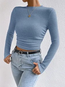 Detail van de blauwe wafelgebreide textuur en gerimpelde taille op deze strakke damestop