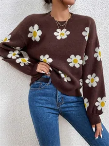 Gros plan sur un pull en maille marron oversize avec des motifs de marguerites blanches