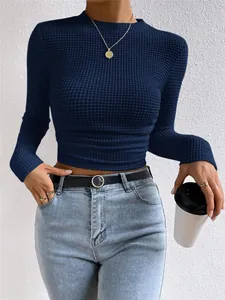 Detail van marineblauwe wafelgebreide crop top met lange mouwen en gerimpelde taille