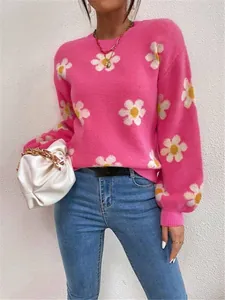 Vue détaillée d'un pull en maille rose à motifs floraux blancs avec une coupe décontractée.
