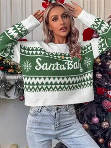 Close-up of green and white Santa Baby knit sweater featuring festive snowflake patterns
