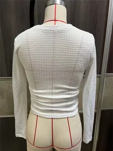 Rugdetail van een witte mesh top met lange mouwen, wafeltextuur en geplooide rug