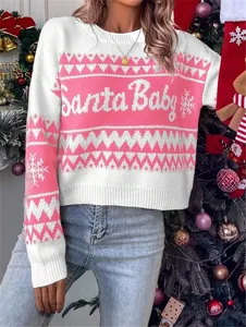 Close-up of pink and white knit sweater with Santa Baby text and snowflake patterns