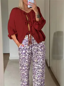Detaillierte Ansicht der roten Strickjacke mit Rundhalsausschnitt und Bindebändern vorne