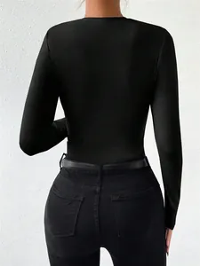 Detailed back view of a minimalist black slim-fit long-sleeve bodysuit with black jeans