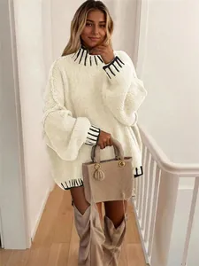 Detail shot of a cream oversized knit sweater featuring black contrast collar and cuffs