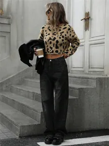 Donna elegante con maglione leopardato e pantaloni neri larghi sulle scale della città.
