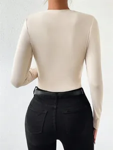 Slim fit long sleeve women's beige bodysuit shown from the back with black jeans