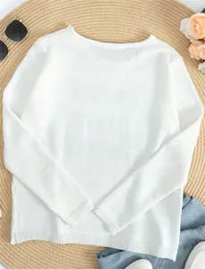Detail view of white long-sleeve knit sweater with round neck and side slit