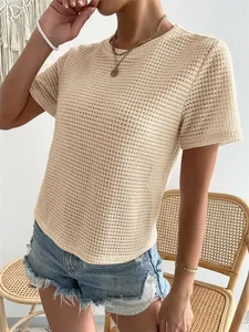 Vista dettagliata di una donna con una t-shirt in maglia a nido d'ape beige.