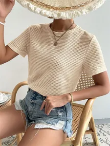 Dettaglio maglietta in maglia beige testurizzata con scollo rotondo e estetica estiva