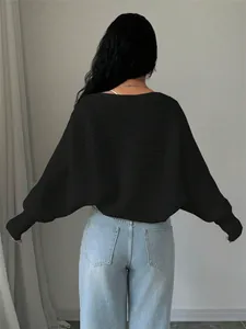 Stylish back view of a black loose knit cropped cardigan for women in a casual setting
