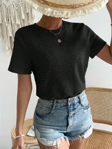Primo piano di una t-shirt nera in maglia a nido d'ape con girocollo e maniche corte.