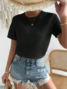 Dettaglio ravvicinato di una t-shirt in maglia nera strutturata con girocollo