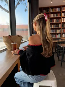 Detail view showing the back and red contrast trim of a vintage black knit sweater