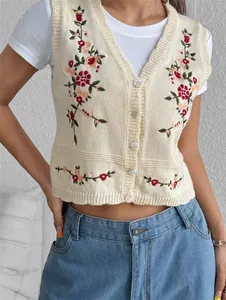 Vue détaillée d'un gilet en maille crème avec des broderies florales colorées et boutons