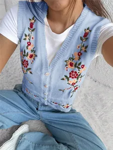 Vue détaillée d'un gilet en maille bleu clair avec de délicates broderies florales colorées
