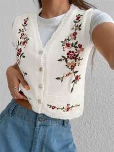 Vue détaillée de la broderie florale complexe sur le gilet en tricot blanc pour femmes.