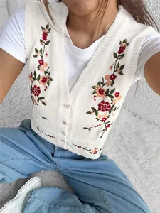 Vue détaillée de la broderie florale colorée sur un gilet en maille blanc pour femme
