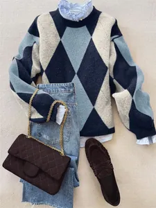 Vue détaillée d'un pull à losanges bleu porté avec un jean et un sac matelassé