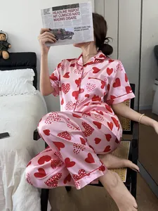 Vue détaillée du pyjama en satin rose à motifs de cœurs dans une chambre cosy