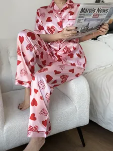 Détail d'un pyjama en satin rose avec imprimé cœurs rouges et col à revers