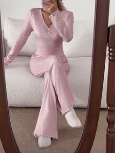 Détail d'un pyjama côtelé rose à cœurs avec col en V boutonné et bordure de laitue