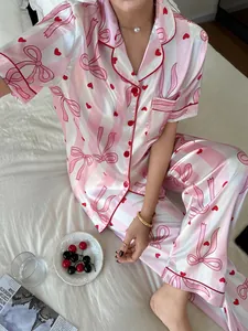 Detailed view of pink striped satin pajama set with bow and heart prints