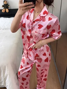 Détail d'un ensemble de pyjama en satin rose pour femme à imprimé cœurs avec pantalon