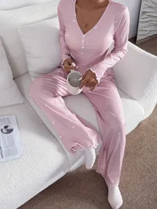 Détail d'un pyjama rose côtelé à col en V avec motif cœurs et bords volantés délicats