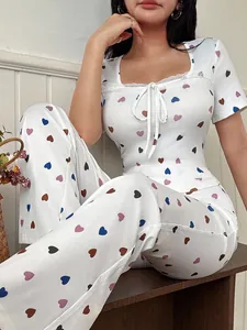 Close-up of a white ribbed pajama set featuring heart print and delicate lace trim detail