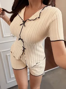 Close-up of women's ribbed pajama set with delicate black bows and contrast piping